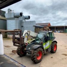 Small forklift in industrial yard setting.