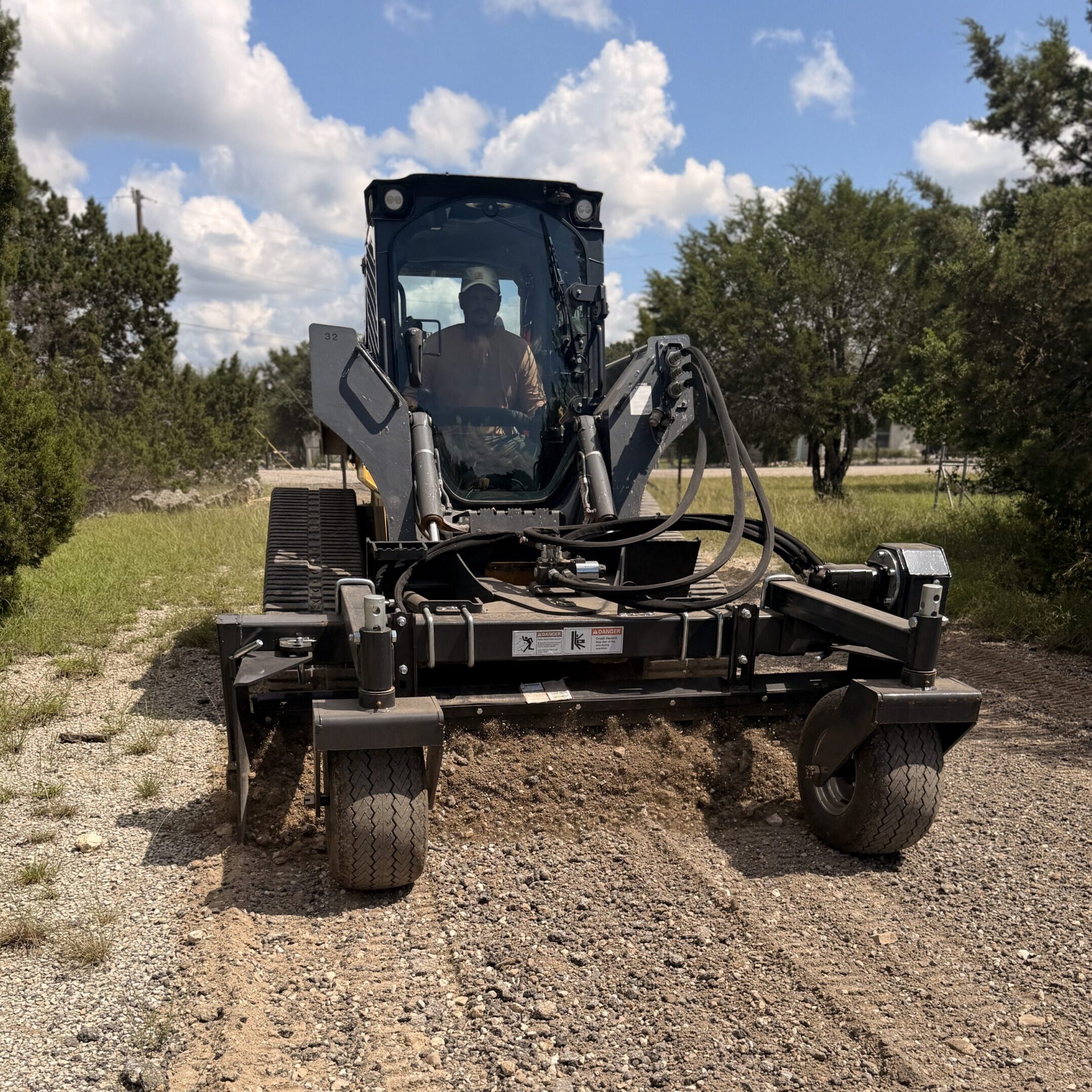 Heavy equipment clearing driveway under blue sky
